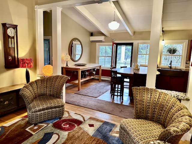 53 Highland Rd, North Truro, MA 02652 - living area with a wall unit AC, wood finished floors, beam ceiling, and baseboard heating