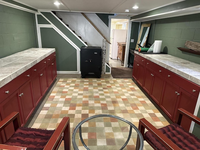 53 Highland Rd, North Truro, MA 02652 - basement with concrete block wall, stairway, freestanding refrigerator, and recessed lighting