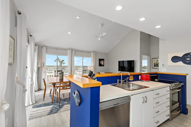 20 Beach Rd, Eastham, MA 02642 - kitchen with stainless steel appliances, a sink, light wood-type flooring, white cabinetry, and high vaulted ceiling