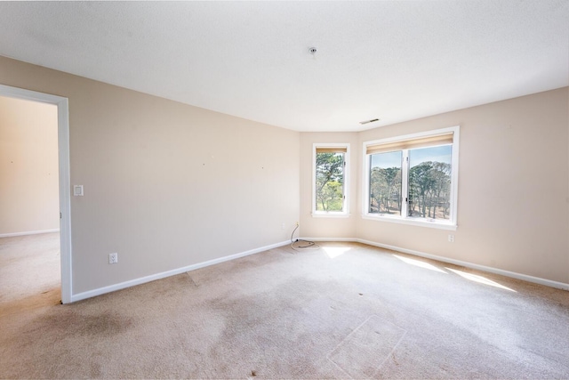 unfurnished room with carpet floors, baseboards, and visible vents