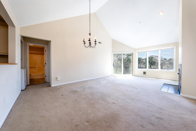 empty room with high vaulted ceiling, baseboards, carpet, and a chandelier