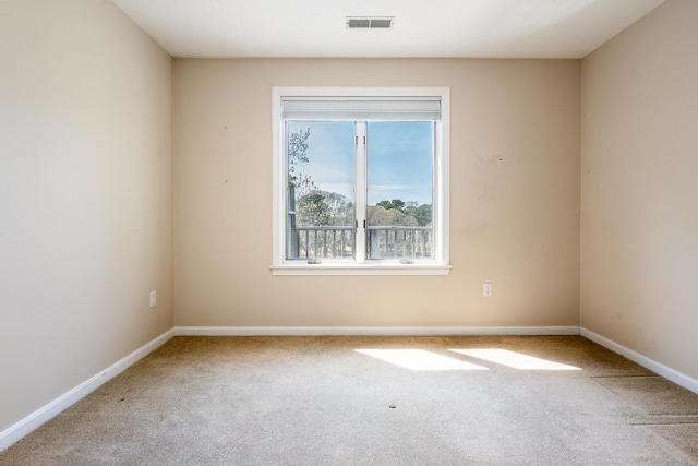 carpeted spare room featuring baseboards and visible vents