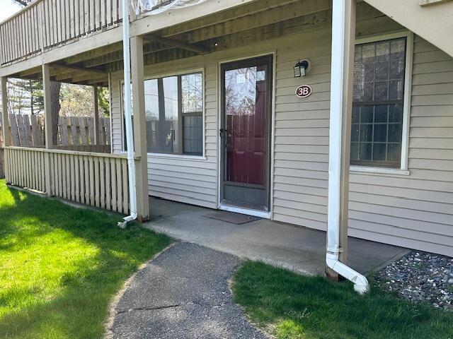 property entrance with a lawn