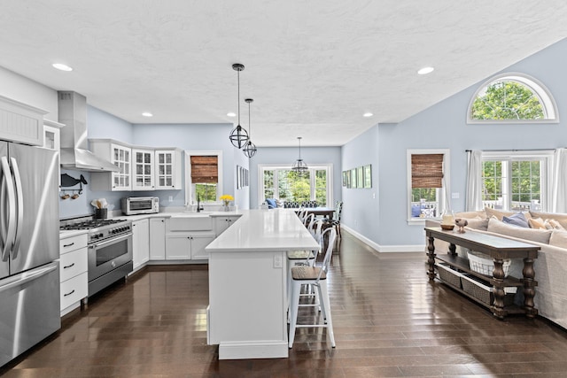 5 Bosuns Ln, Bourne, MA 02532 - kitchen with stainless steel appliances, wall chimney exhaust hood, a breakfast bar, dark wood finished floors, and recessed lighting