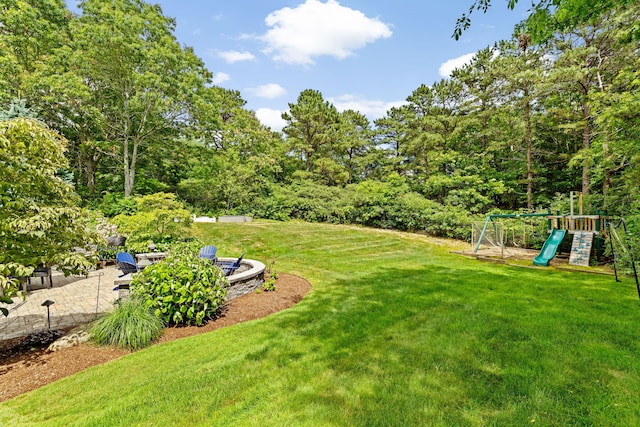 5 Bosuns Ln, Bourne, MA 02532 - view of grassy yard with a playground, a fire pit, and a patio area