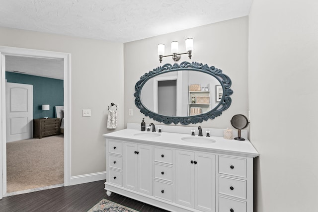 5 Bosuns Ln, Bourne, MA 02532 - bathroom with double vanity, wood finished floors, and a textured ceiling