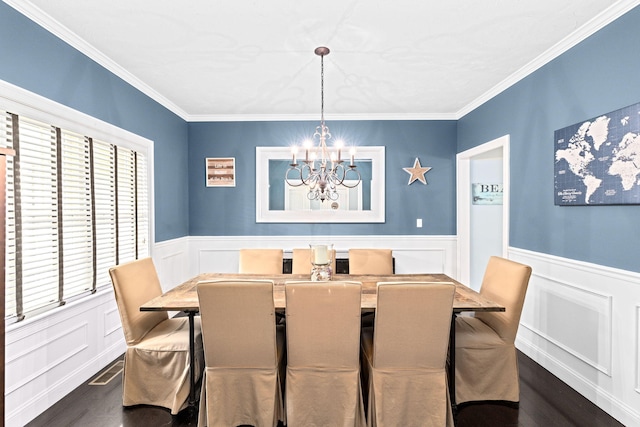 5 Bosuns Ln, Bourne, MA 02532 - dining space featuring dark wood-style floors, a chandelier, ornamental molding, a wainscoted wall, and a decorative wall