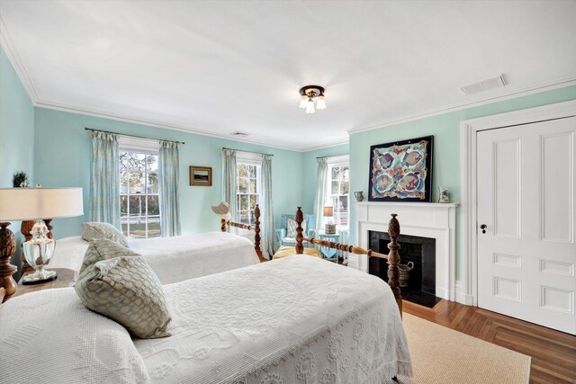 bedroom featuring multiple windows, dark parquet flooring, and crown molding