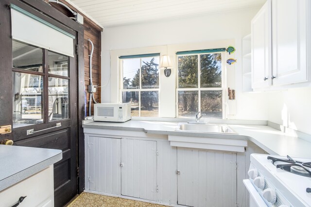150 Old State Hwy Unit 4, Eastham, MA 02642 - kitchen featuring white microwave, a sink, light countertops, white cabinetry, and gas range