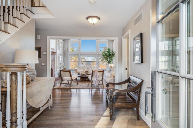 foyer entrance featuring stairs, visible vents, and wood finished floors
