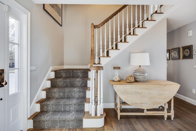 staircase with baseboards and wood finished floors
