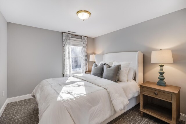 bedroom featuring baseboards, visible vents, and dark colored carpet