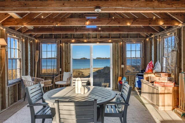 sunroom featuring a water view