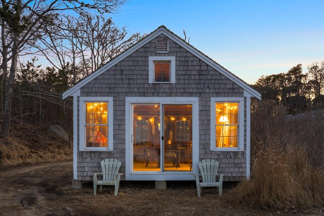 back of house at dusk with an outbuilding