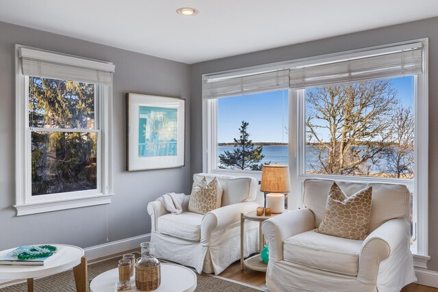 sitting room featuring baseboards and a water view