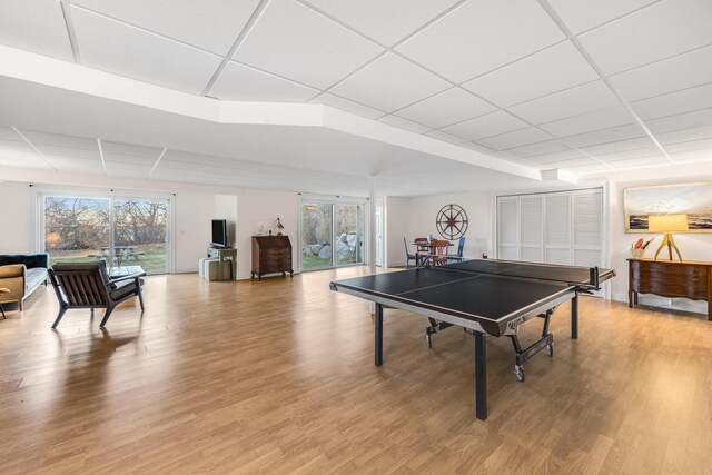 game room with light wood-style flooring and a paneled ceiling