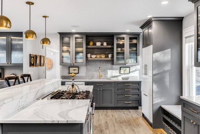 kitchen featuring gray cabinetry, high end range, and a sink