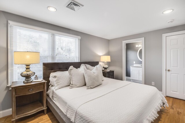 bedroom with visible vents, baseboards, connected bathroom, recessed lighting, and light wood-style floors