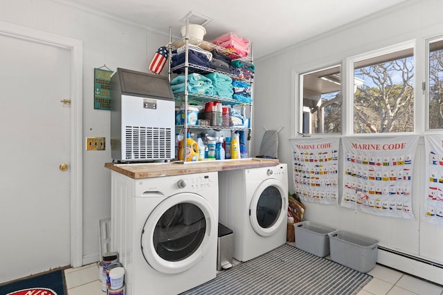 clothes washing area with crown molding, a baseboard radiator, light tile patterned floors, and washing machine and clothes dryer