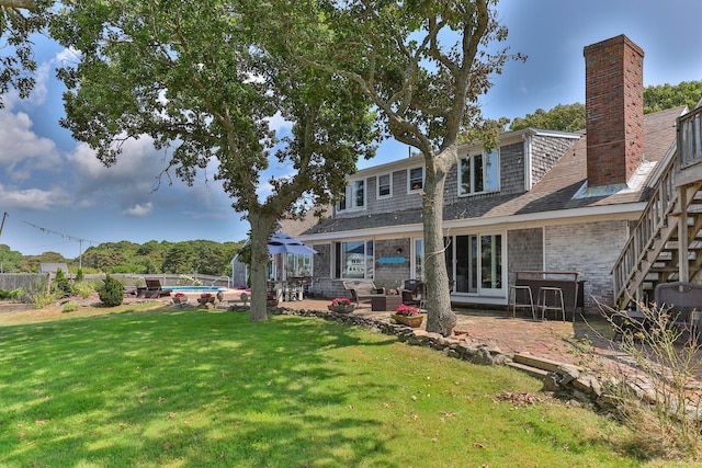 back of house featuring a patio area, a lawn, and a swimming pool with hot tub