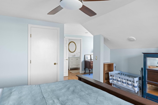 bedroom featuring ensuite bath, light wood-type flooring, vaulted ceiling, and ceiling fan