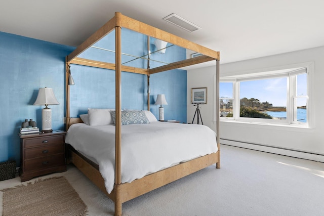 bedroom featuring light carpet, a baseboard radiator, and a water view