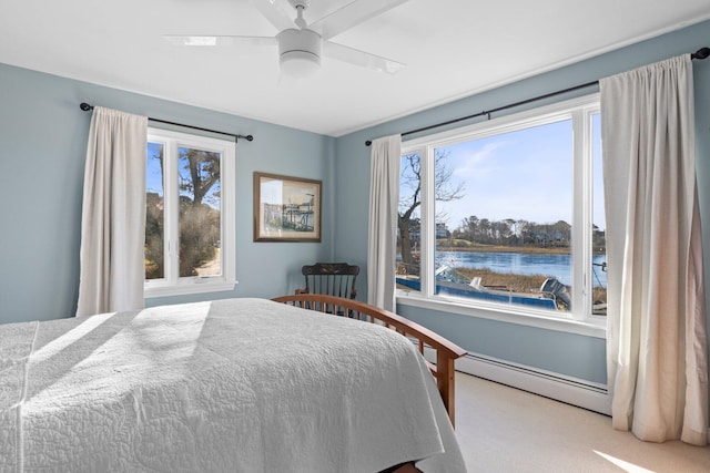 carpeted bedroom featuring ceiling fan, a baseboard radiator, and a water view
