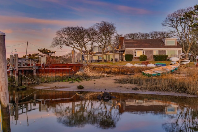back house at dusk with a water view