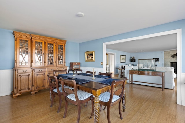 dining space featuring a fireplace, light hardwood / wood-style floors, and radiator