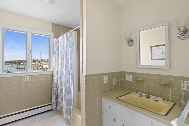 bathroom with baseboard heating, shower / bath combo, tile patterned flooring, tile walls, and vanity