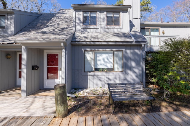 view of front of property featuring a shingled roof and a wooden deck