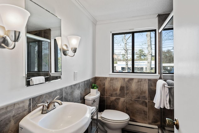 full bath with crown molding, toilet, tile walls, a sink, and a stall shower