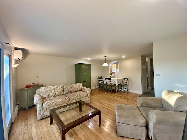 living room with a wall unit AC and light wood-type flooring