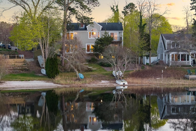 back of property at dusk with a water view