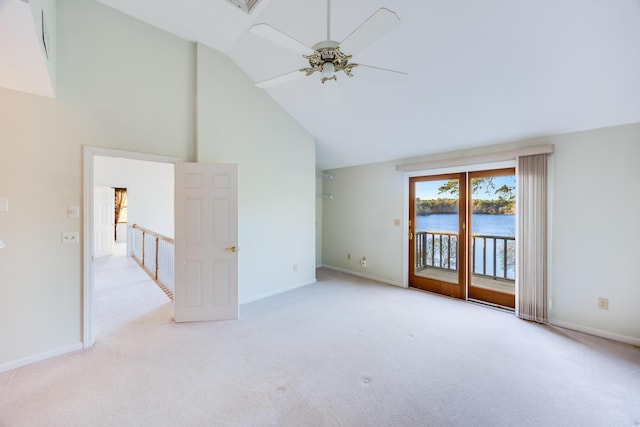 unfurnished room featuring a ceiling fan, baseboards, a water view, high vaulted ceiling, and light colored carpet