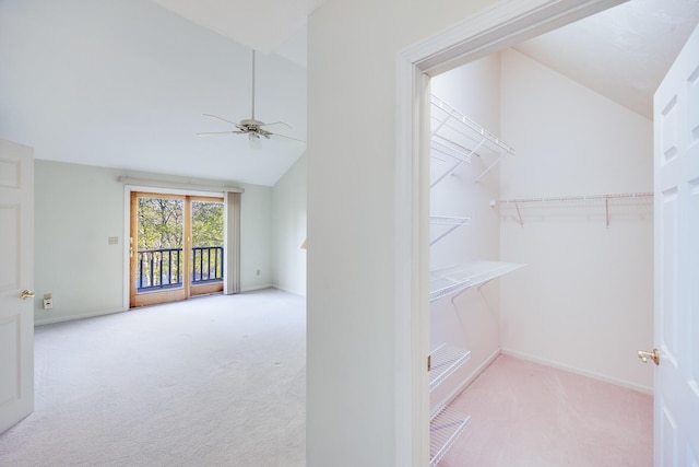 walk in closet with ceiling fan, carpet floors, and vaulted ceiling