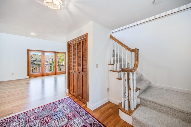 staircase featuring baseboards, recessed lighting, and wood finished floors