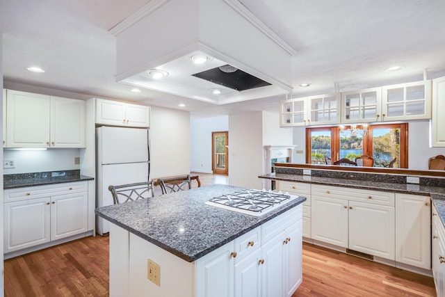 kitchen featuring recessed lighting, white cabinetry, light wood-type flooring, and white appliances
