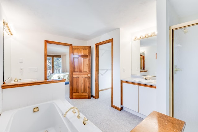 full bath featuring connected bathroom, a whirlpool tub, and vanity