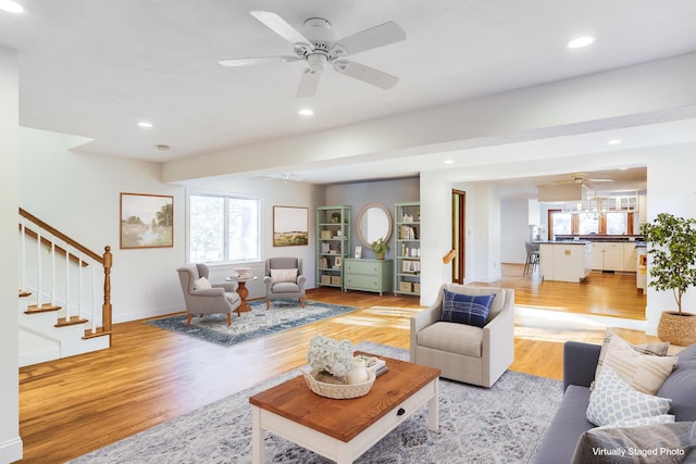 living room featuring light wood-type flooring, stairs, a ceiling fan, and recessed lighting