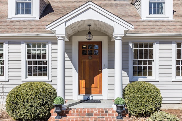 entrance to property featuring a shingled roof