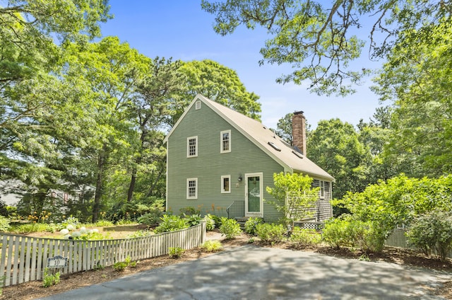 10 Devonshire Ln, South Dennis, MA 02660 - view of side of property featuring a chimney and entry steps