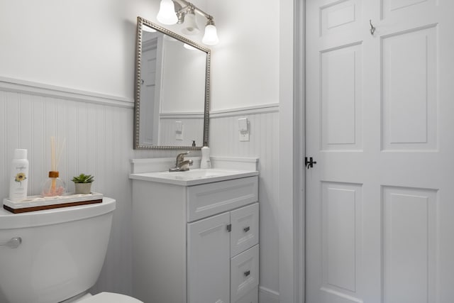 10 Devonshire Ln, South Dennis, MA 02660 - bathroom with vanity, wainscoting, and a decorative wall