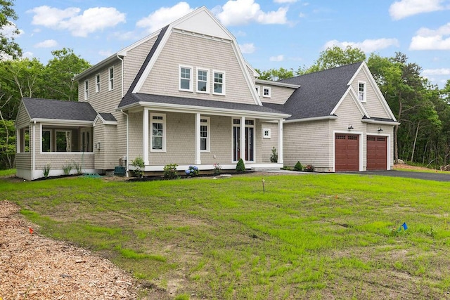 view of front facade with a garage, a front lawn, and a porch