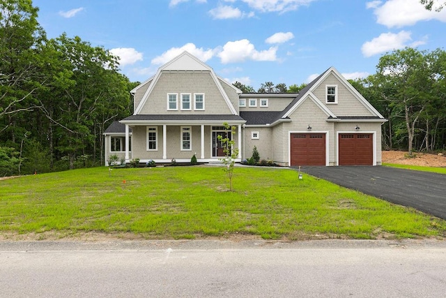 craftsman inspired home with covered porch, a front yard, and a garage