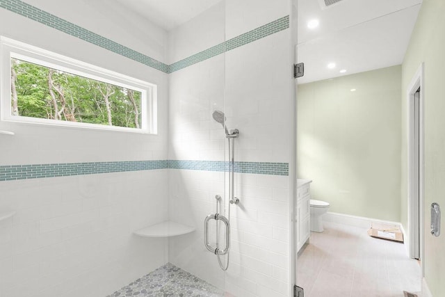 bathroom featuring a shower with door, toilet, and tile patterned floors