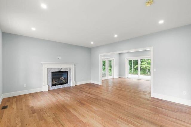 unfurnished living room with light hardwood / wood-style flooring and a fireplace