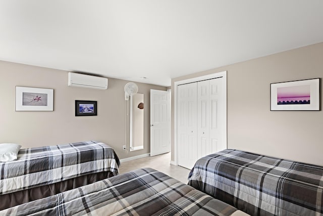 bedroom with a closet, an AC wall unit, and baseboards