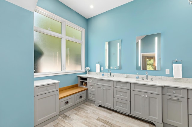 full bathroom with double vanity, a sink, and wood finished floors