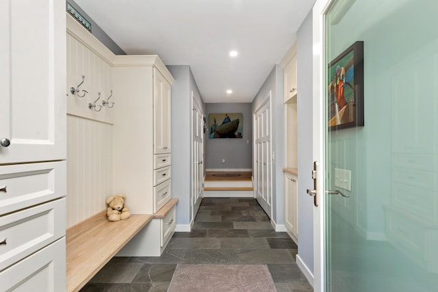 mudroom with stone finish flooring, baseboards, and recessed lighting